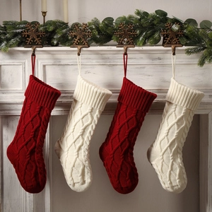 Set of four red and white cable knit Christmas stockings hanging on a festive mantelpiece