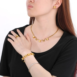 Detailed view of the 18K gold plated butterfly jewelry set worn on model