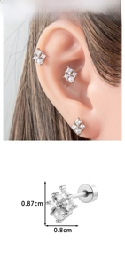 Macro detail of geometric silver cartilage studs with zircon and pearl inlays for women