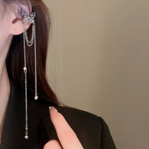 Close-up of sparkling zircon butterfly ear cuff with long tassel chains and pearls