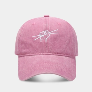 Close-up of pink washed cotton baseball cap with white abstract drumming embroidery