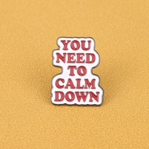 Enamel brooch with 'YOU NEED TO CALM DOWN' lettering on a yellow background