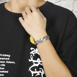Close-up of polished silver titanium steel cuban link bracelet on a male model's wrist