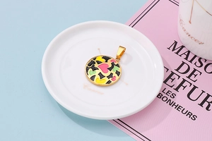 Macro shot of gold-edged circular pendant with colorful geometric enamel mosaic patterns