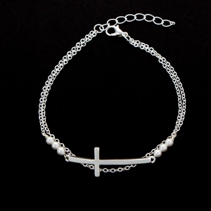 Silver cross layered bracelet with freshwater pearls on a black background