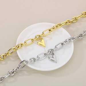 Vista ravvicinata di bracciali a catena ovali oro e argento con ciondoli a cuore 3D