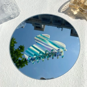 Pince à cheveux Y2K en acétate avec rayures bleues et blanches sur un miroir