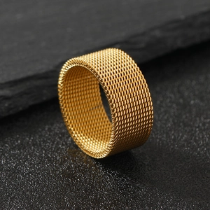 Detail shot of 10mm golden mesh ring with woven texture on a dark stone background