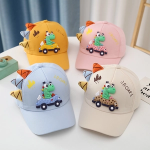 Detail of four colorful cotton baseball caps for kids with dinosaur and car patches