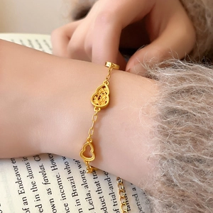Nahaufnahme des vergoldeten hohlen Blumen-Gourd-Armbands am Handgelenk bei warmem Licht