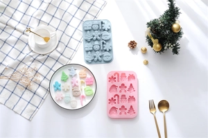 Detail view of pink and blue Christmas silicone molds with gingerbread man and snowman shapes