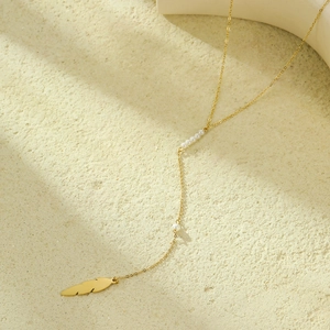 Long gold necklace for women featuring a delicate feather pendant and white pearls