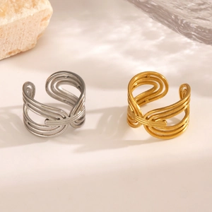 Minimalist open geometric twist rings in gold and silver finish on a neutral surface