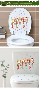 Detail view of festive Christmas toilet stickers with winter birds and stars on ceramic surface