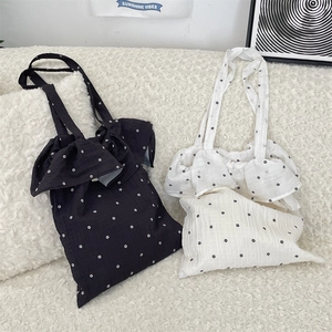 Detail of floral chiffon tote bags with ruffle edges in black and white canvas