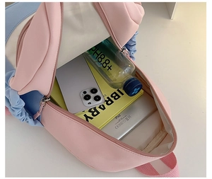 Spacious interior of pink and blue backpack showing storage for iPad, books and water bottle