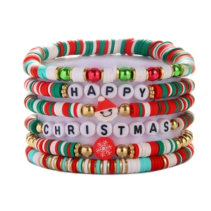 Detailed stack of Christmas clay bead bracelets with Happy Christmas charms on white background