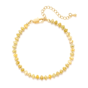Vue détaillée des perles en pierre naturelle jaune et du fermoir doré du bracelet