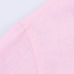 Detailed macro view of pink shirt fabric showing premium woven texture and stitching