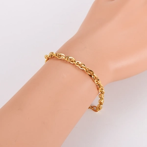 Bracciale a catena geometrica dorata lucida con maglie ovali sul polso di un modello