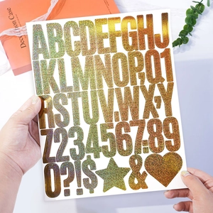 Close-up of 2-inch gold glitter letter and number stickers for DIY gift decoration