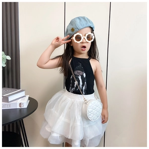 Girl modeling black halter top with white quilted mini round chain bag and tutu