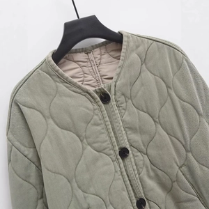 Veste matelassée vert olive en coton avec motif à vagues et boutons sur un cintre