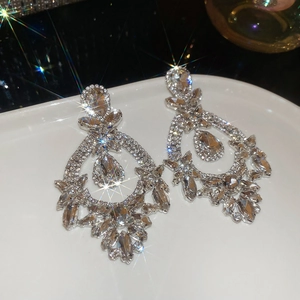 Sparkling waterdrop pendant earrings with silver finish and dazzling crystals on a tray