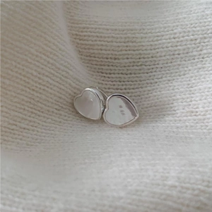 Elegant 925 sterling silver heart stud earrings with pearlescent shell inlay on white knit