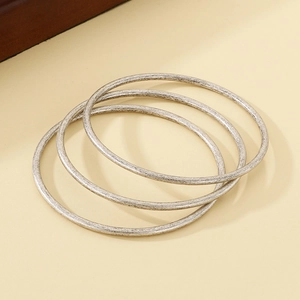 Detail of three stackable 3mm vintage silver stainless steel rings with brushed finish