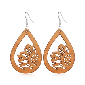 Detailed view of hollow sunflower laser-cut pattern on brown wooden teardrop earrings