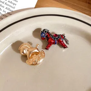 Broches cheval exquises en émail doré et pierres précieuses sur une assiette vintage