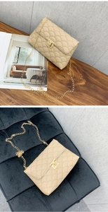 Détail du sac beige matelassé à écailles avec serrure dorée et texture élégante
