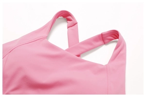 Macro shot of cross-strap yoga bra showing reinforced stitching and pink elastic fabric