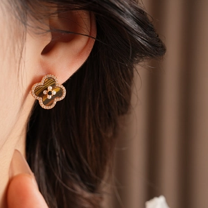 Detail of four-leaf clover stud earring in rose gold with tiger eye stone and crystals