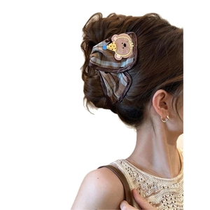 Brown checkered hair claw clip with cute teddy bear accessory shown on a hairstyle