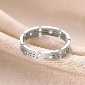 Macro shot of silver hollow rectangular geometric ring on champagne silk background