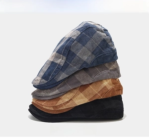 Detailed texture of corduroy beret hats in blue plaid, grey, brown plaid and black