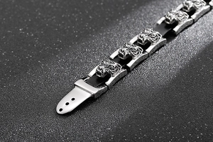 Macro detail of silver stainless steel tiger head emblem on black braided leather bracelet