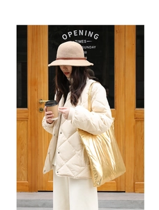 Chic beige quilted jacket paired with a metallic gold tote bag in a casual street setting
