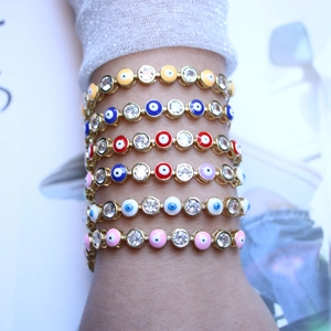 Colorful evil eye bracelets with enamel beads and zircons on a model's wrist