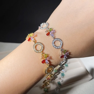 Detail of flower zircon bracelets in gold and silver plating on woman's wrist