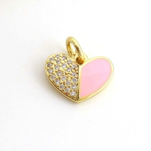 Detail of pink enamel heart pendant with sparkling crystals and golden metal finish