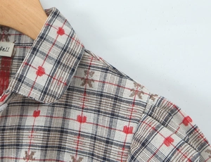 Detail of plaid shirt collar with red and blue checks on beige textured fabric