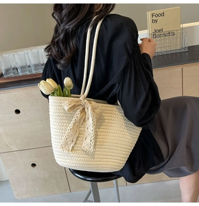 Detail of hand-woven cream tote bag with delicate lace bow and tulip decoration