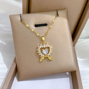 Luxury heart pendant necklace in gold with zircon stones and bow detail on a velvet gift box