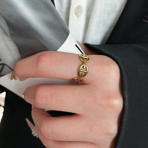 Detail of gold-plated stainless steel chain ring worn on finger with elegant suit