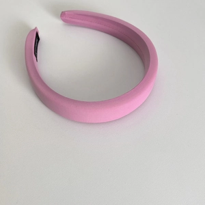 Detail of pink sponge padded headband showing fabric texture and non-slip inner lining