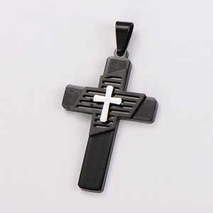 Detail of black metal cross pendant with silver center and geometric engraving