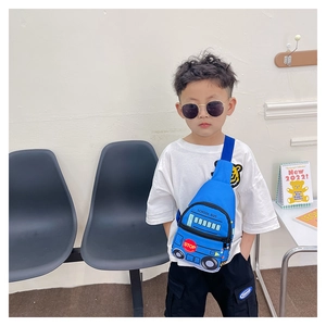 Detail of blue school bus cartoon chest bag worn by a boy in a minimalist indoor setting